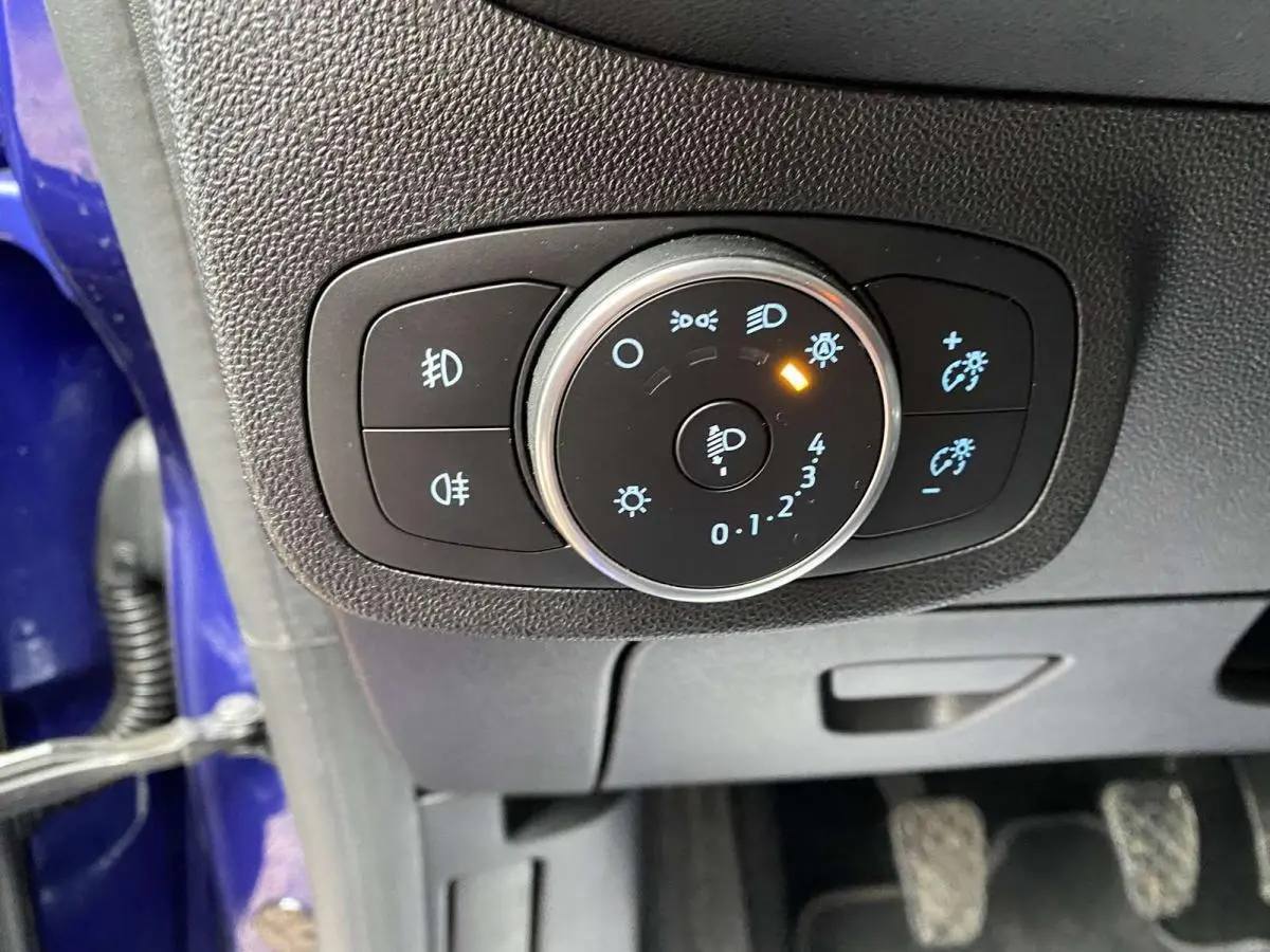 Gros plan sur la commande d'éclairage intérieur d'une Ford Fiesta 2017 bleu foncé, avec réglage des phares activé.