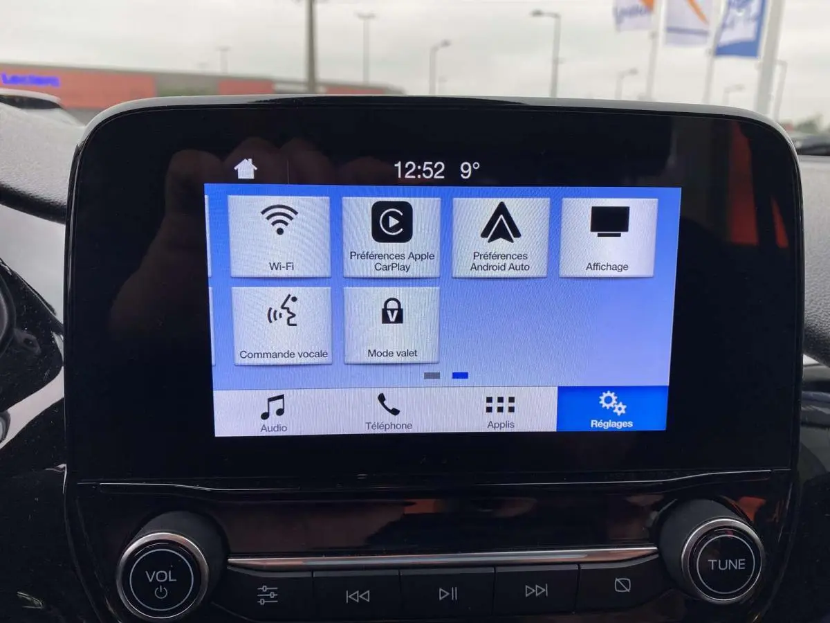 Écran tactile central de la Ford Fiesta 2017 bleu foncé, affichant les réglages Wi-Fi, Apple CarPlay et Android Auto.