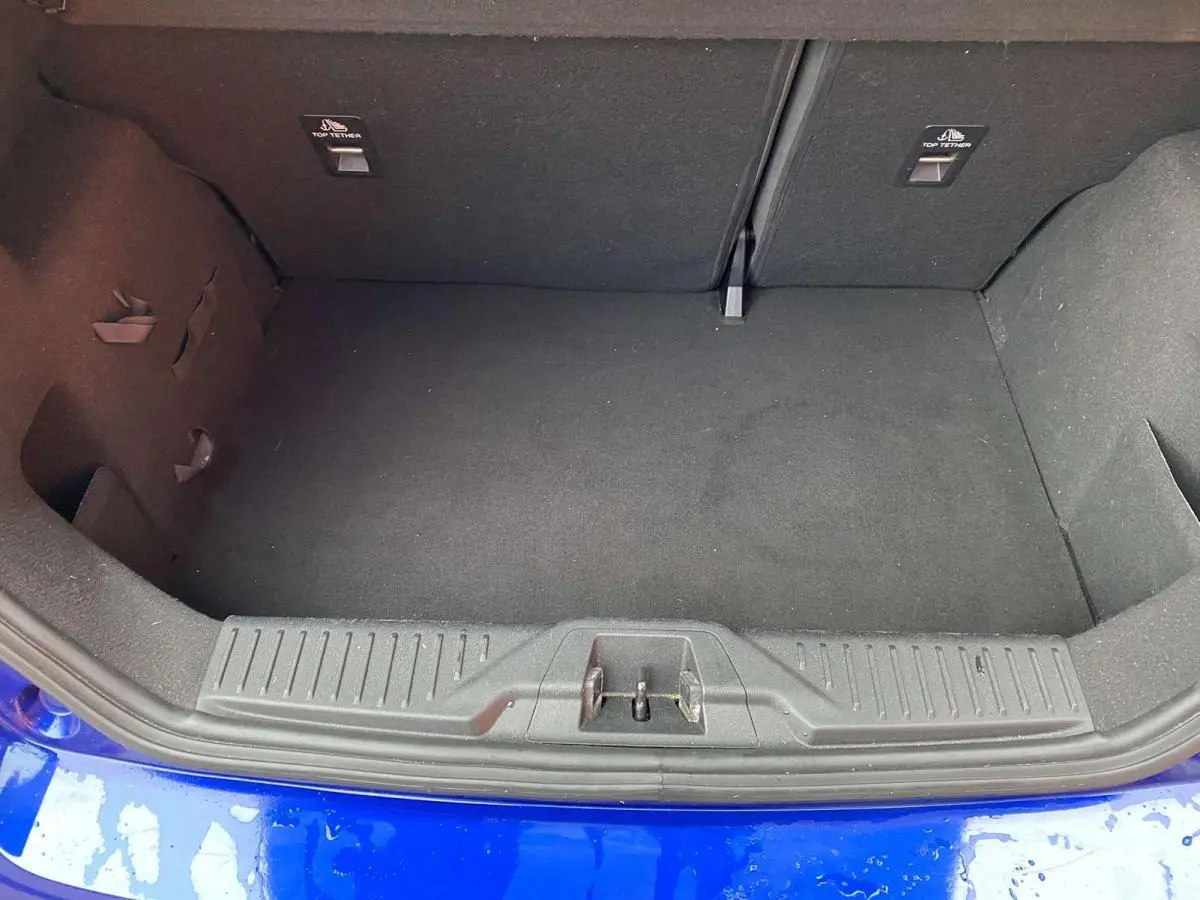 Coffre ouvert de Ford Fiesta 1.1i Trend bleu foncé, vue plongeante sur l’espace de chargement vide.