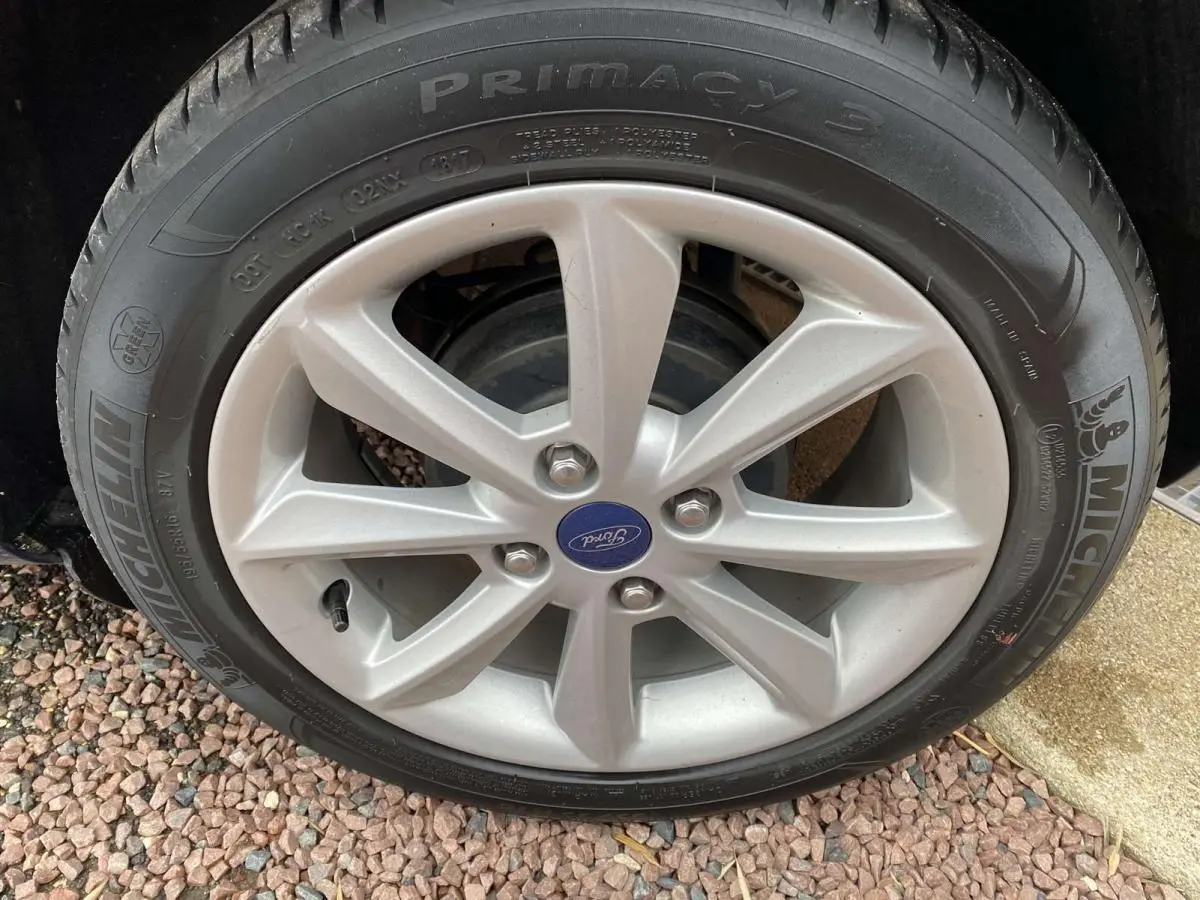 Gros plan sur la jante alliage argentée et pneu Michelin d’une Ford Fiesta bleu foncé, version Trend 2017.