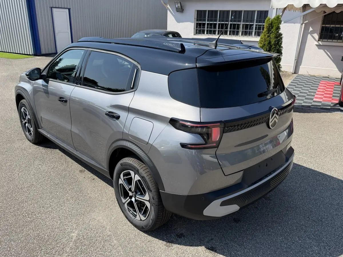 Vue 3/4 arrière droite du Citroën C3 Aircross gris clair avec toit noir et feux arrière LED distinctifs.