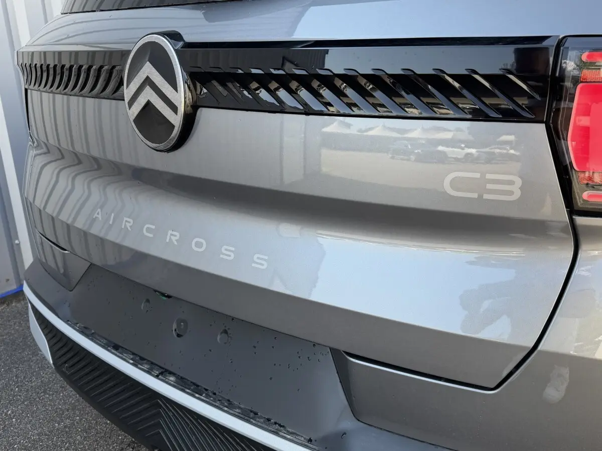Gros plan arrière droit du Citroën C3 Aircross gris clair avec logo et lettrage distinctifs sur le hayon.