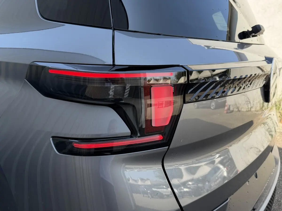 Gros plan sur le feu arrière droit gris clair du Citroën C3 Aircross hybride 2026 avec détails noirs et rouges distinctifs.
