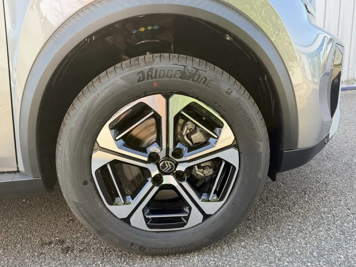 Gros plan sur la roue avant gauche gris clair du Citroën C3 Aircross 2026 avec jante noire et argentée distinctive.