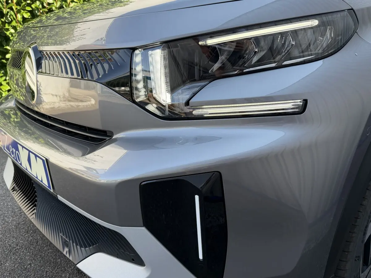 Gros plan sur l’avant droit gris clair du Citroën C3 Aircross 2026, mettant en valeur le phare LED et la calandre distinctive.