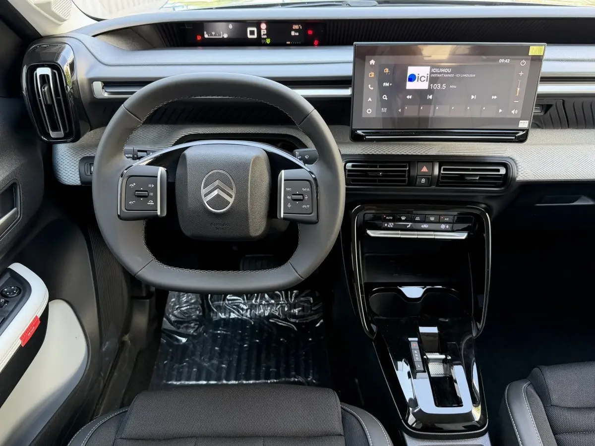 Vue intérieure avant du Citroën C3 Aircross gris clair, volant cuir multifonctions et grand écran tactile central.