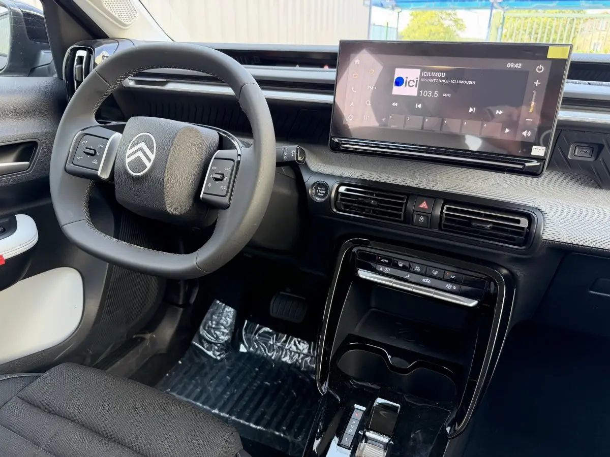 Vue intérieure de face du tableau de bord et volant cuir noir de la Citroën C3 Aircross hybride 2026 avec écran tactile 10,25 pouces.