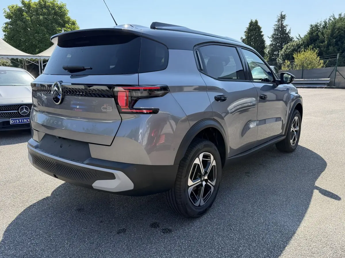 Vue 3/4 arrière droite d'un Citroën C3 Aircross gris clair avec toit noir et feux arrière LED distinctifs.