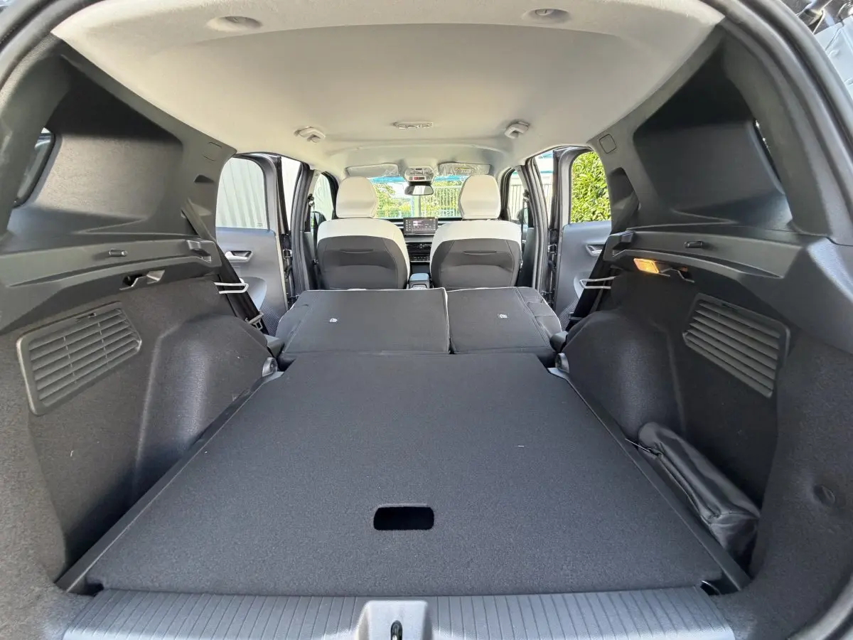 Vue intérieure du coffre avec banquette arrière rabattue du Citroën C3 Aircross gris clair, montrant l'espace de chargement plat.