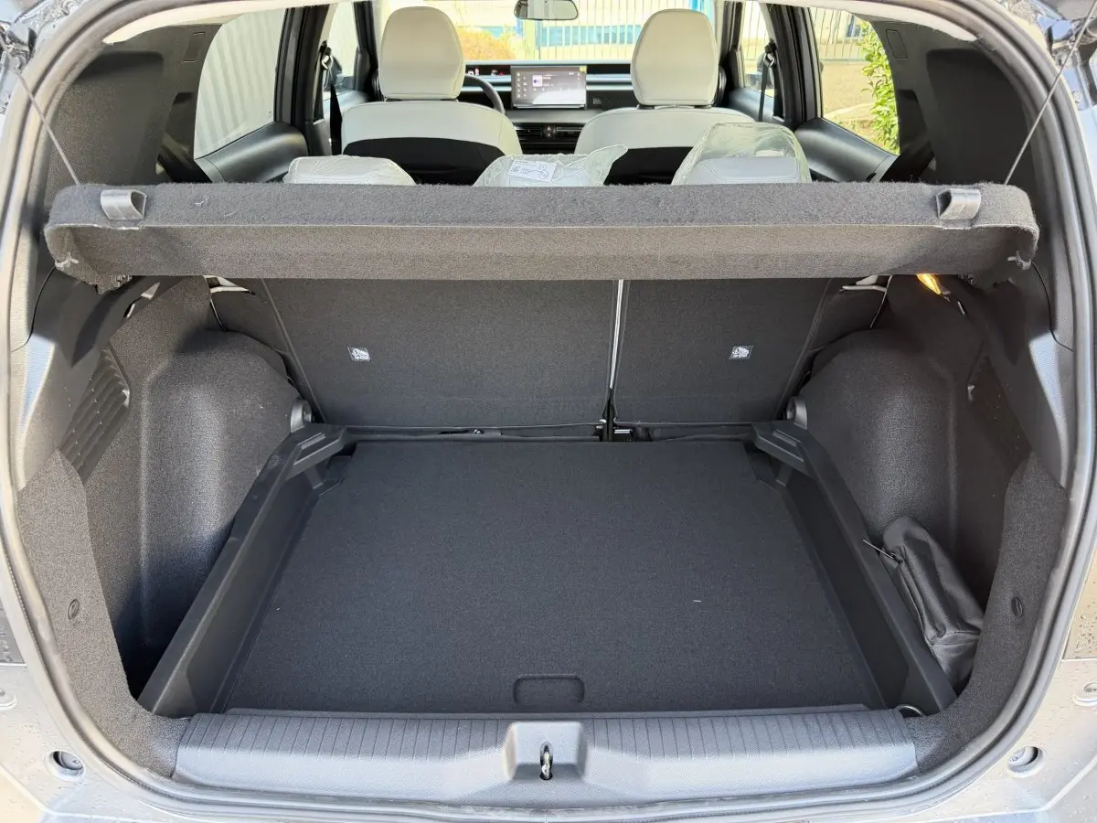 Coffre ouvert vu de l'arrière d'un Citroën C3 Aircross gris clair avec banquette arrière et tableau de bord visible.