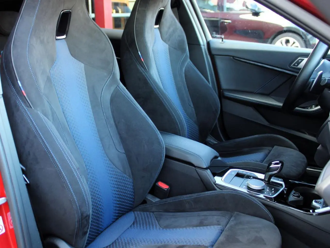 Intérieur BMW Série 1 118d 2022, vue côté droit sur sièges M Sport en tissu Trigon Alcantara noir et bleu.