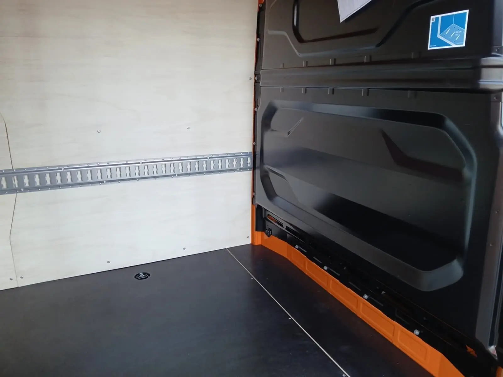 Intérieur du Renault Master L2H2 2026, vue du compartiment de chargement avec parois bois claires et plancher noir.
