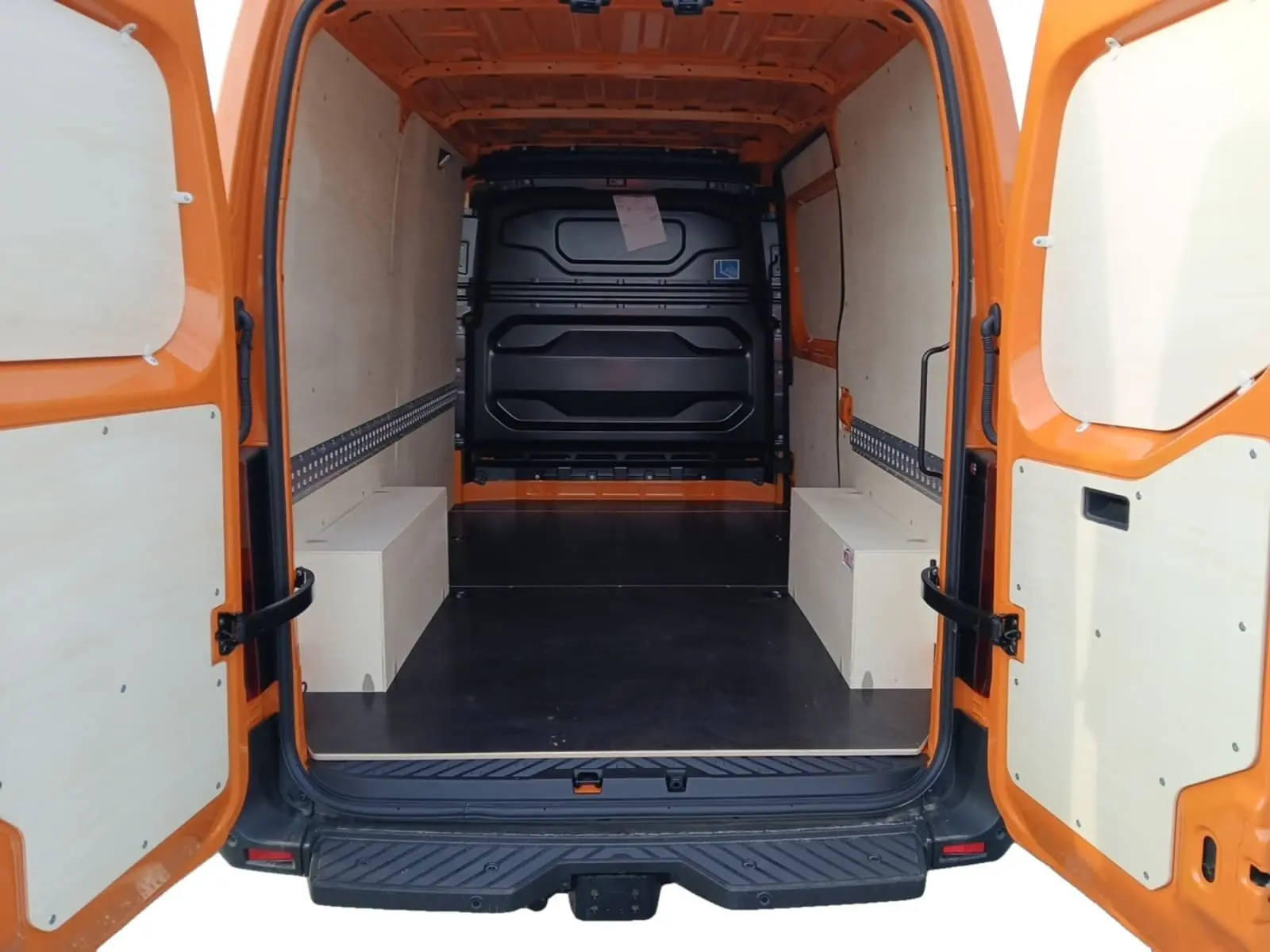 Vue arrière ouverte du Renault Master L2H2 3T5 orange, montrant l’espace de chargement avec aménagements bois clairs.