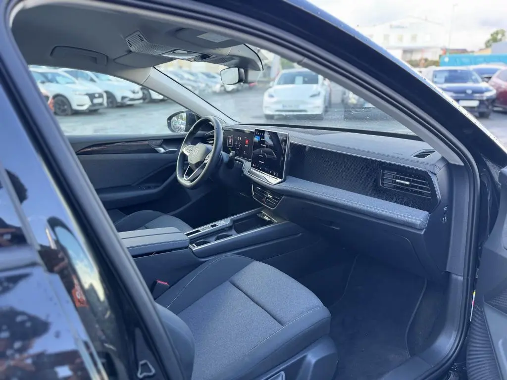Intérieur avant droit de la Volkswagen Passat SW noire 2024, avec tableau de bord numérique et écran tactile central.