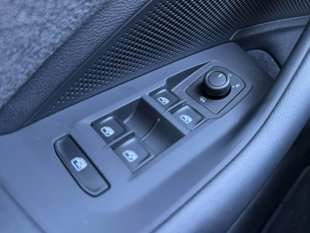 Commande des vitres et réglage des rétroviseurs côté gauche intérieur d'une Volkswagen Passat SW noire 2024