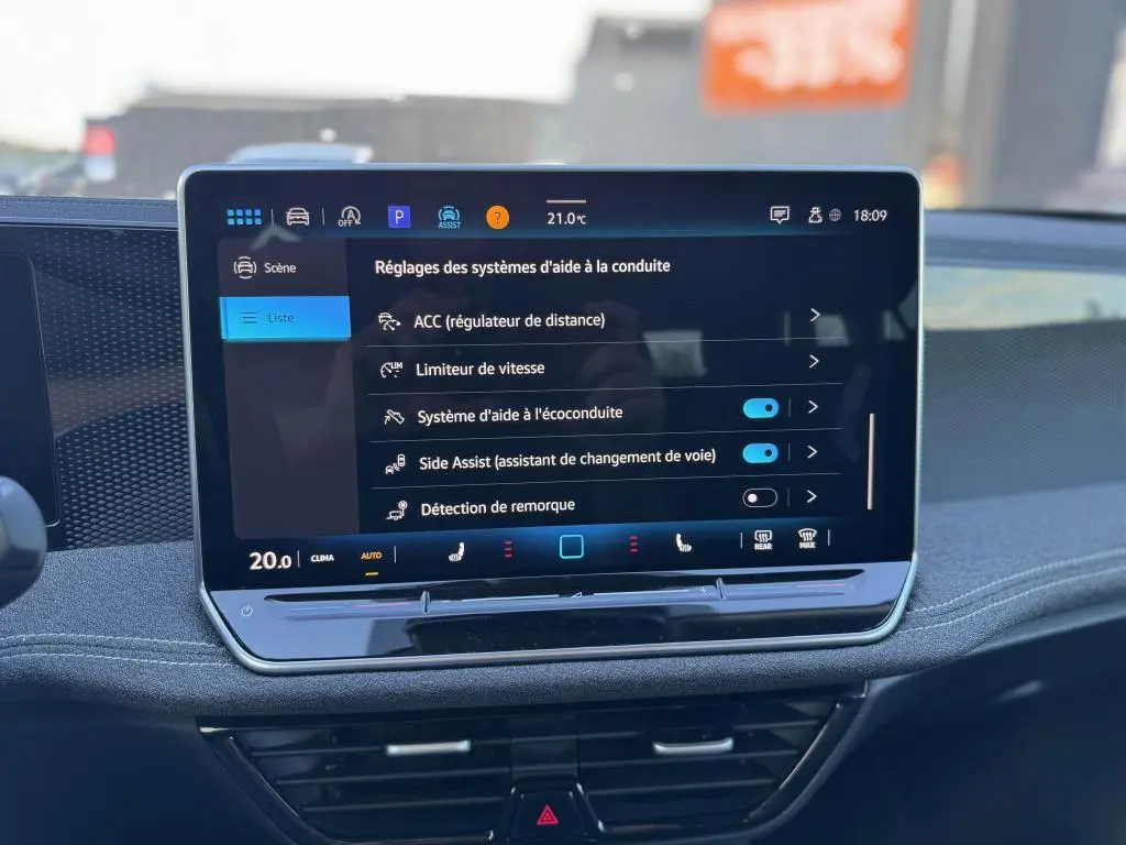 Écran tactile central affichant les réglages d'aide à la conduite dans une Volkswagen Passat SW noire 2024.