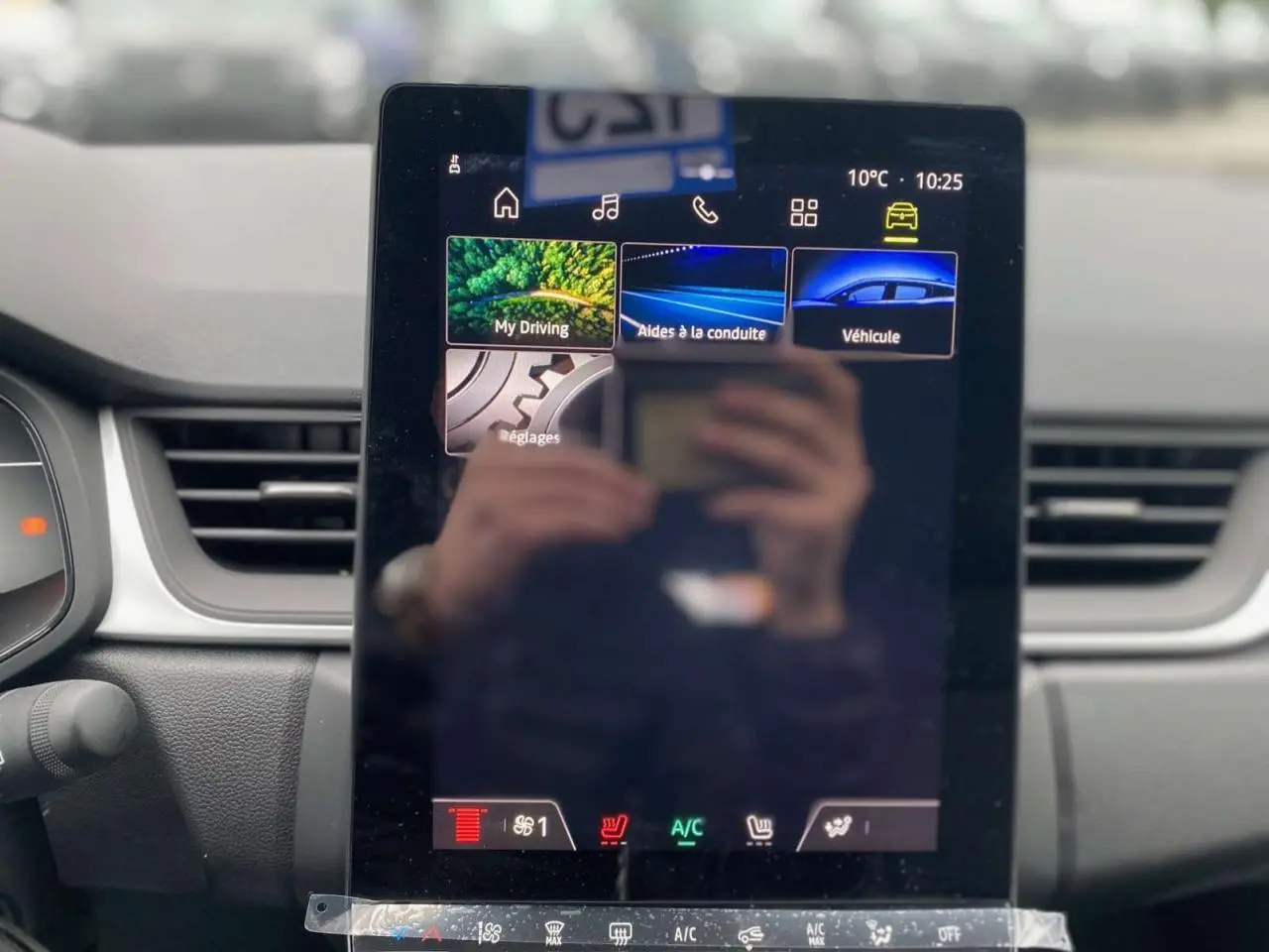 Écran tactile central du tableau de bord du Renault Captur 2025, affichant les aides à la conduite et réglages.