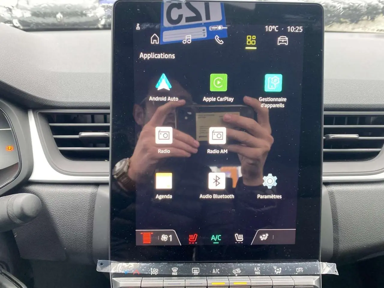 Écran tactile central du Renault Captur 2025 montrant les applications Android Auto et Apple CarPlay, avec commandes climatisation visibles.