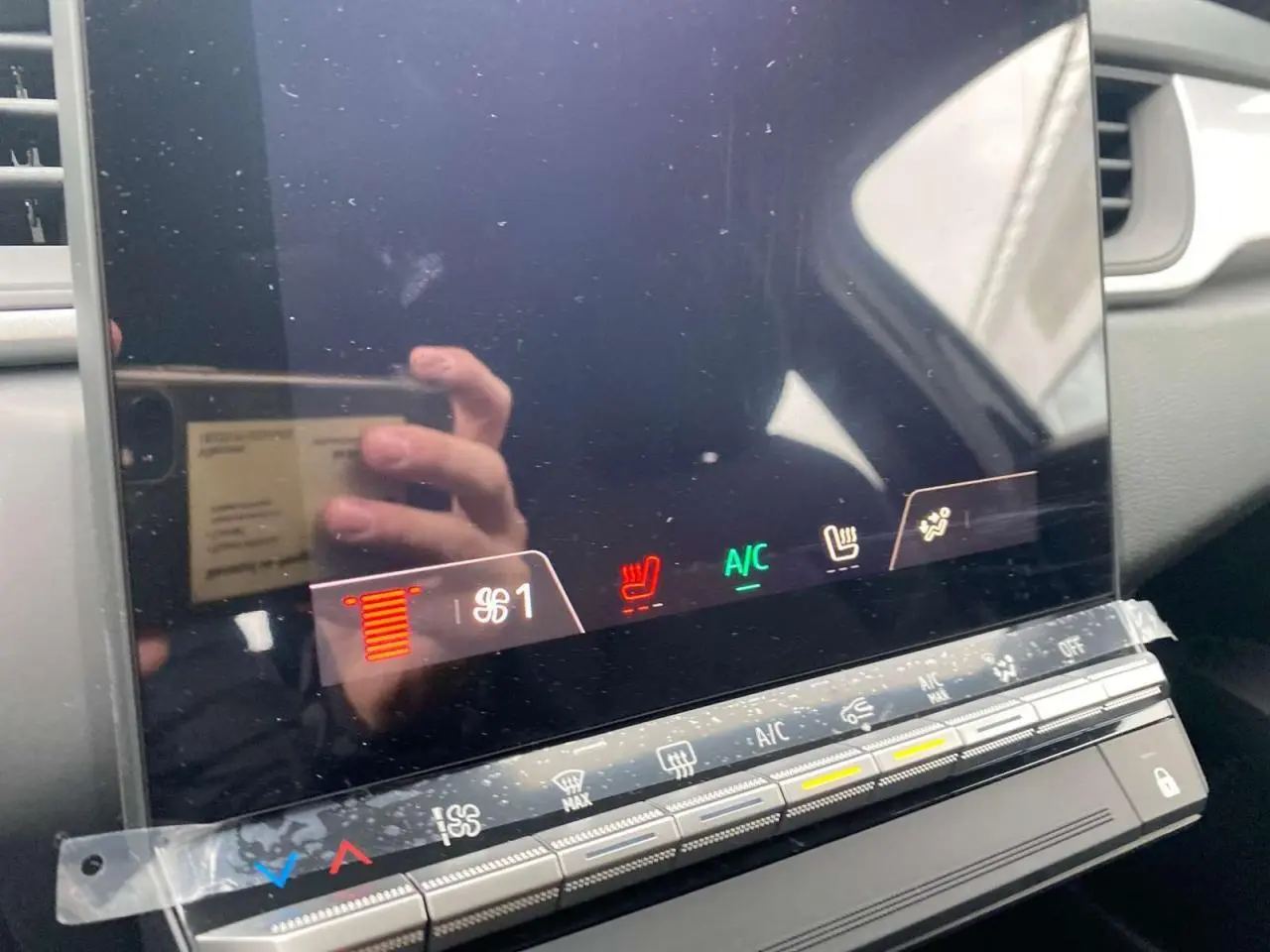 Détail de la console centrale tactile du Renault Captur 2025 avec commandes de climatisation et sièges chauffants.