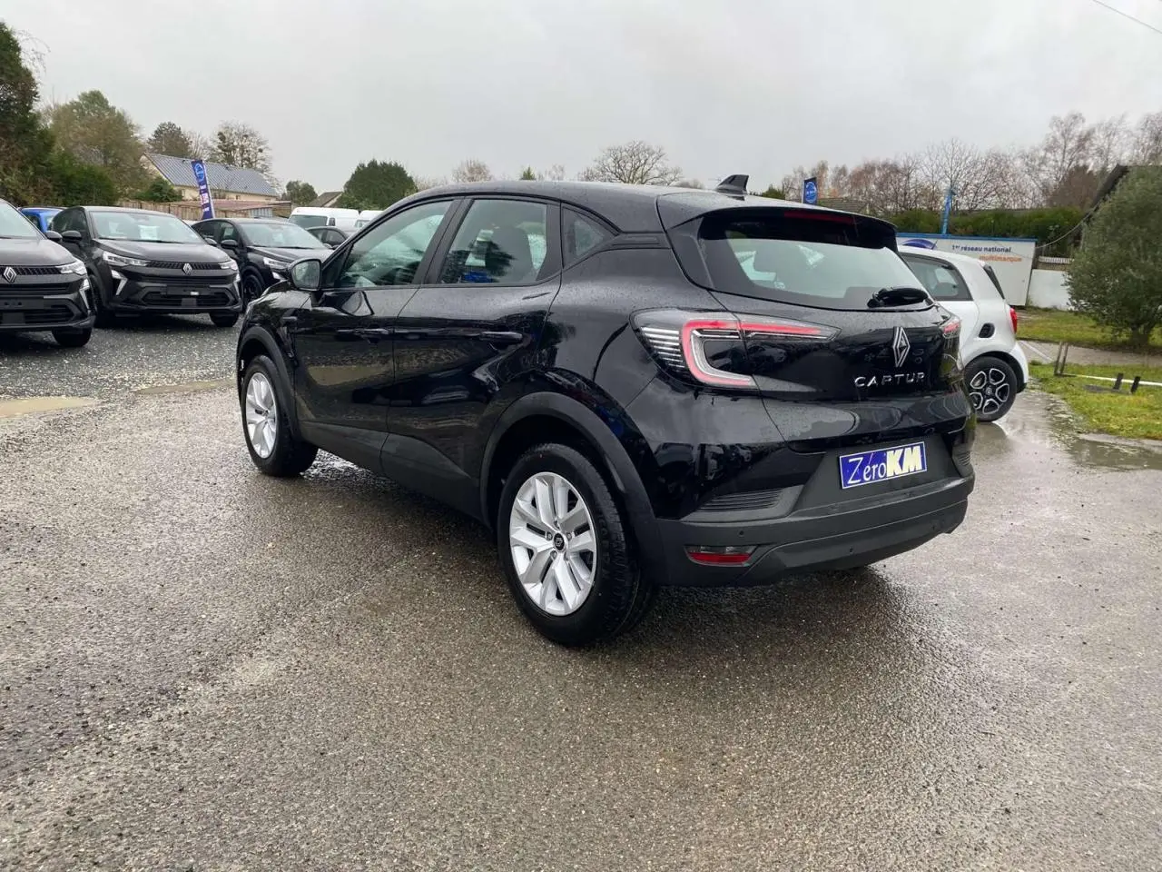 Renault Captur noir étoilé vu en 3/4 arrière droit, avec feux arrière LED et antenne requin noire brillante.