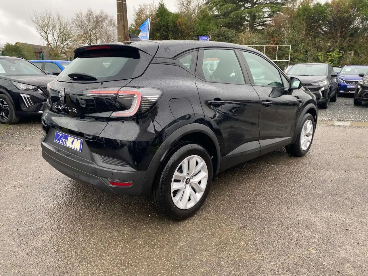Vue 3/4 arrière droite du Renault Captur noir étoilé 2025 avec feux arrière LED et jantes blanches.