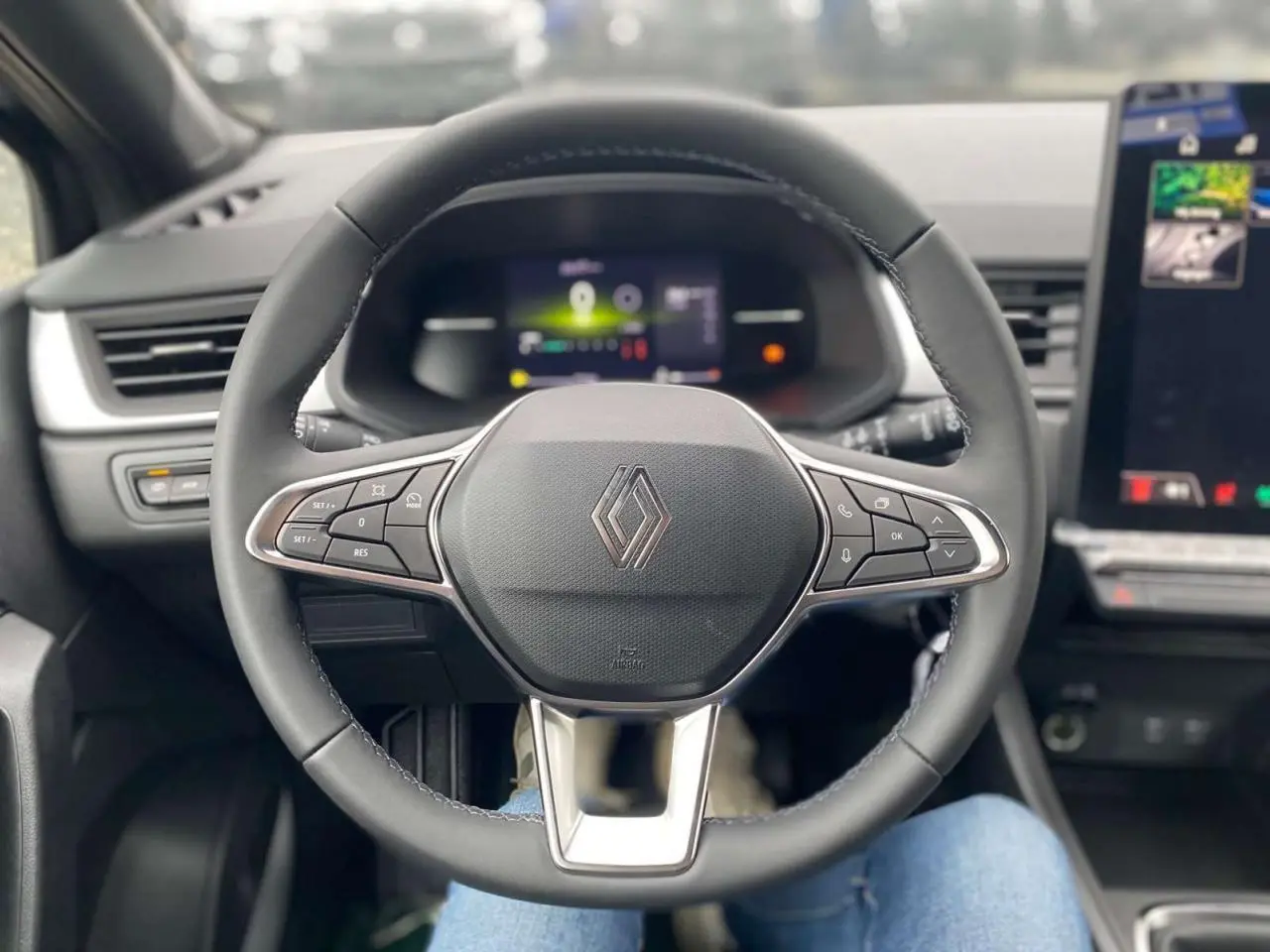 Vue centrée sur le volant noir du Renault Captur 2025 avec commandes intégrées et tableau de bord numérique flou.