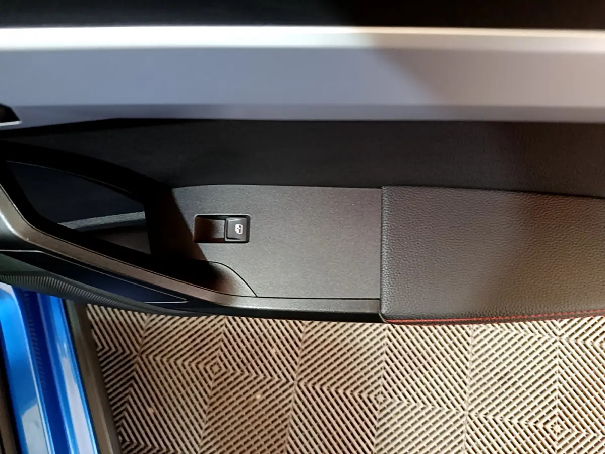 Détail de la porte côté conducteur bleu du SEAT Arona 2022 avec bouton de verrouillage centralisé visible.