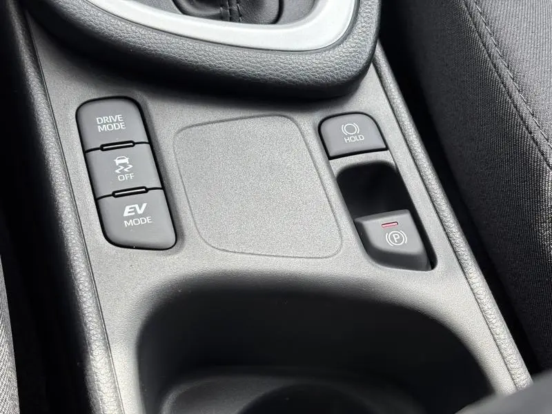 Gros plan sur la console centrale noire de la Toyota Yaris 116h Dynamic 2025 avec boutons Drive Mode, EV Mode et frein électrique.
