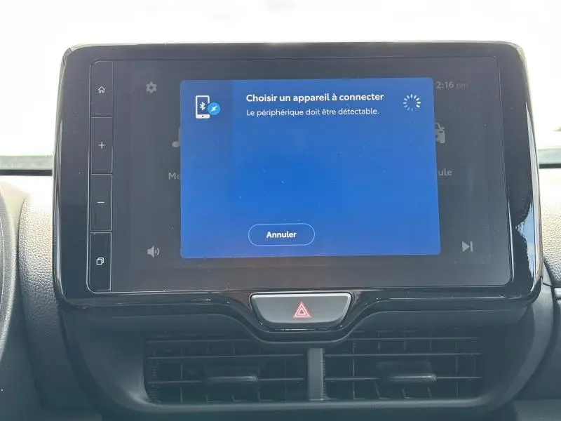 Écran tactile central de la Toyota Yaris 116h Dynamic 5p MC24 2025 affichant une connexion Bluetooth, avec bouton de signal d’alerte en dessous.