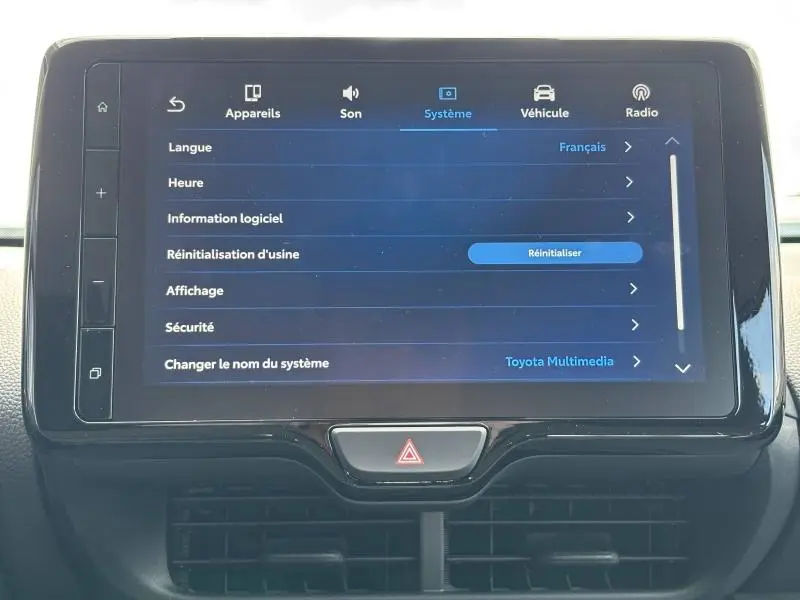 Écran tactile central de la Toyota Yaris 116h Dynamic 2025 affichant le menu système en français, intérieur noir.