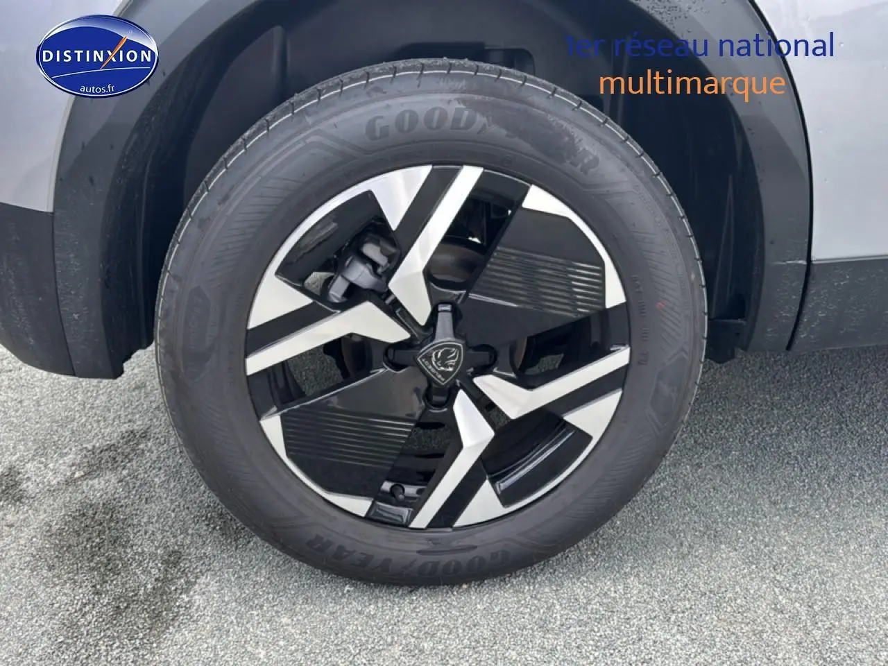 Gros plan sur la roue avant droite avec jante alu bicolore du Peugeot 2008 gris artense.