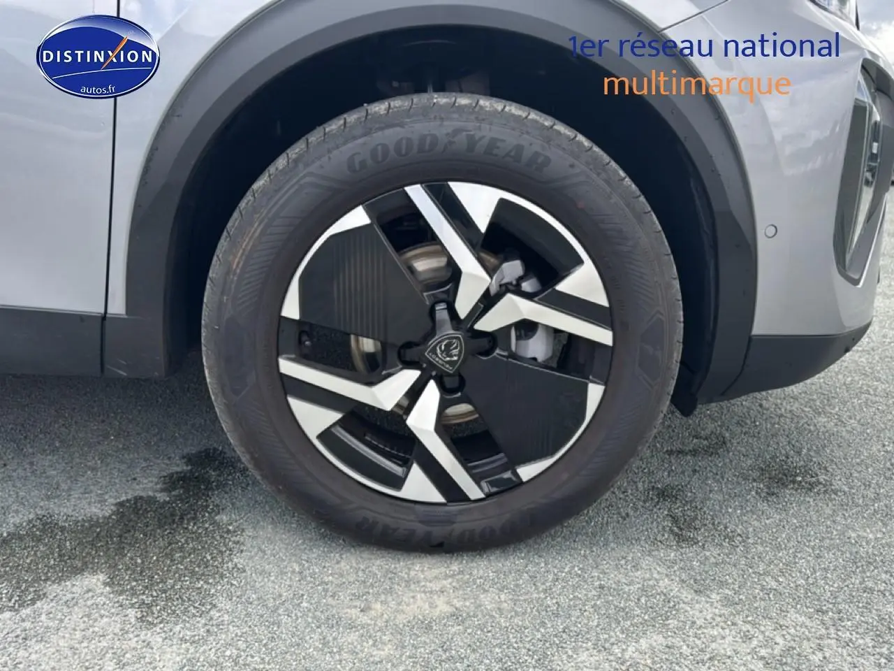 Gros plan sur la roue avant droite avec jante alu bicolore du Peugeot 2008 gris Artense.