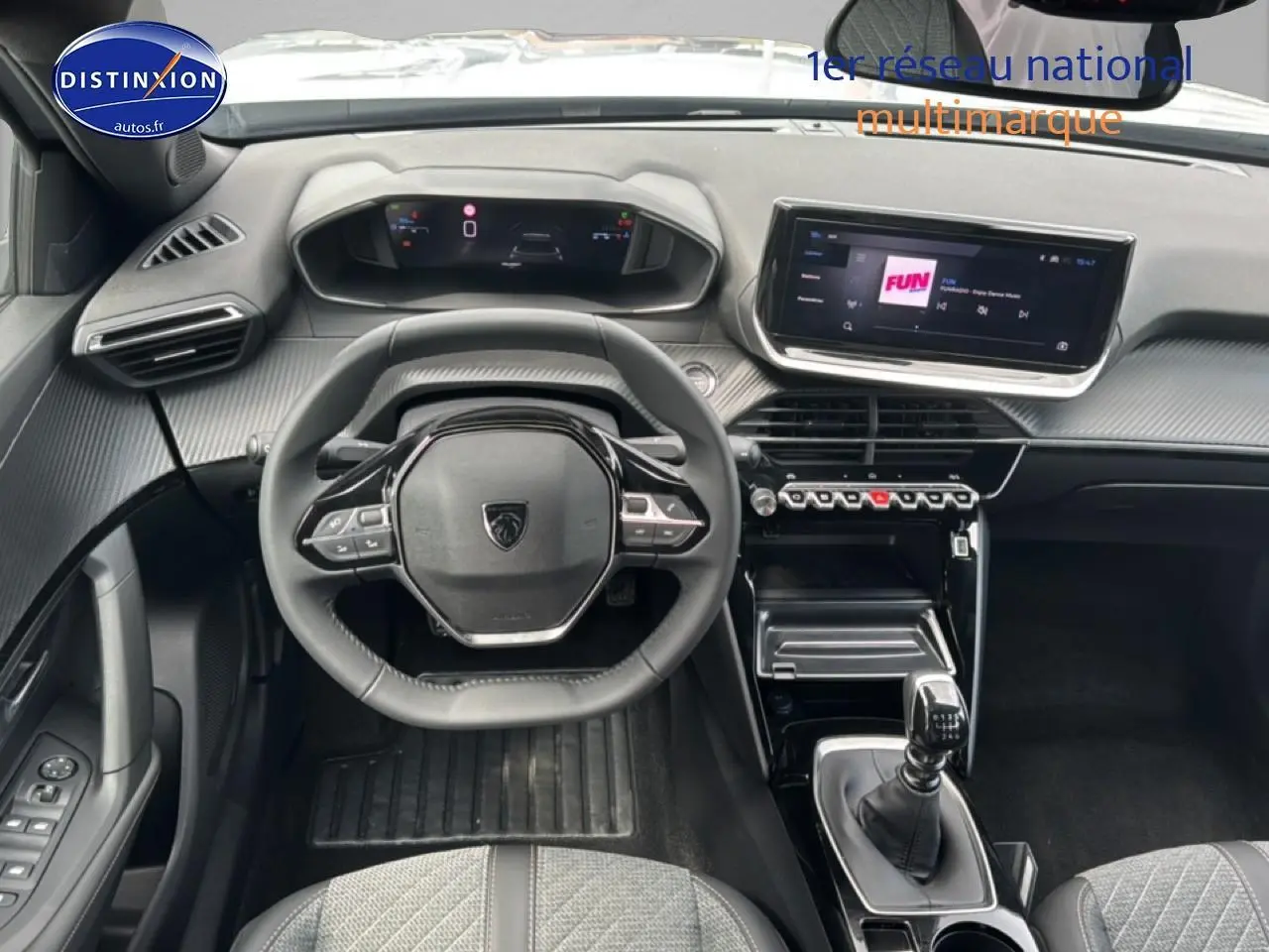 Vue intérieure avant du Peugeot 2008 1.2 100 Allure 2025, volant multifonction, écran tactile et levier de boîte manuelle.