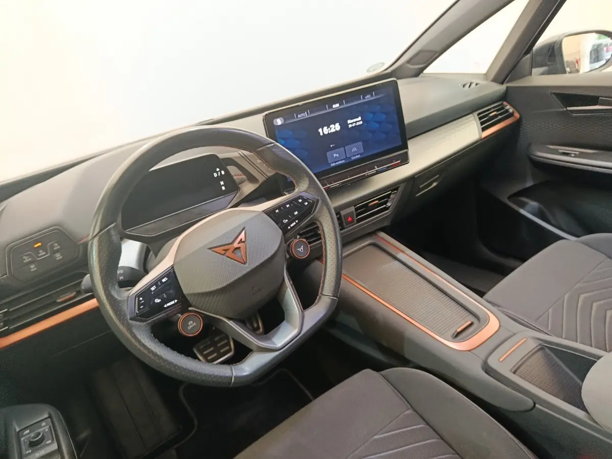 Vue intérieure côté conducteur du CUPRA BORN 230ch 2023, volant cuir avec inserts cuivrés et écran tactile central 12 pouces.