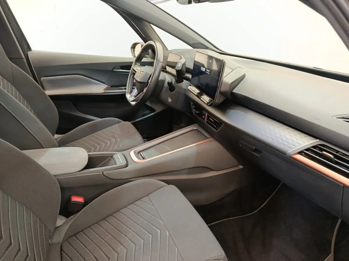 Intérieur côté conducteur du CUPRA Born gris foncé 2023, avec tableau de bord moderne et écran tactile central.