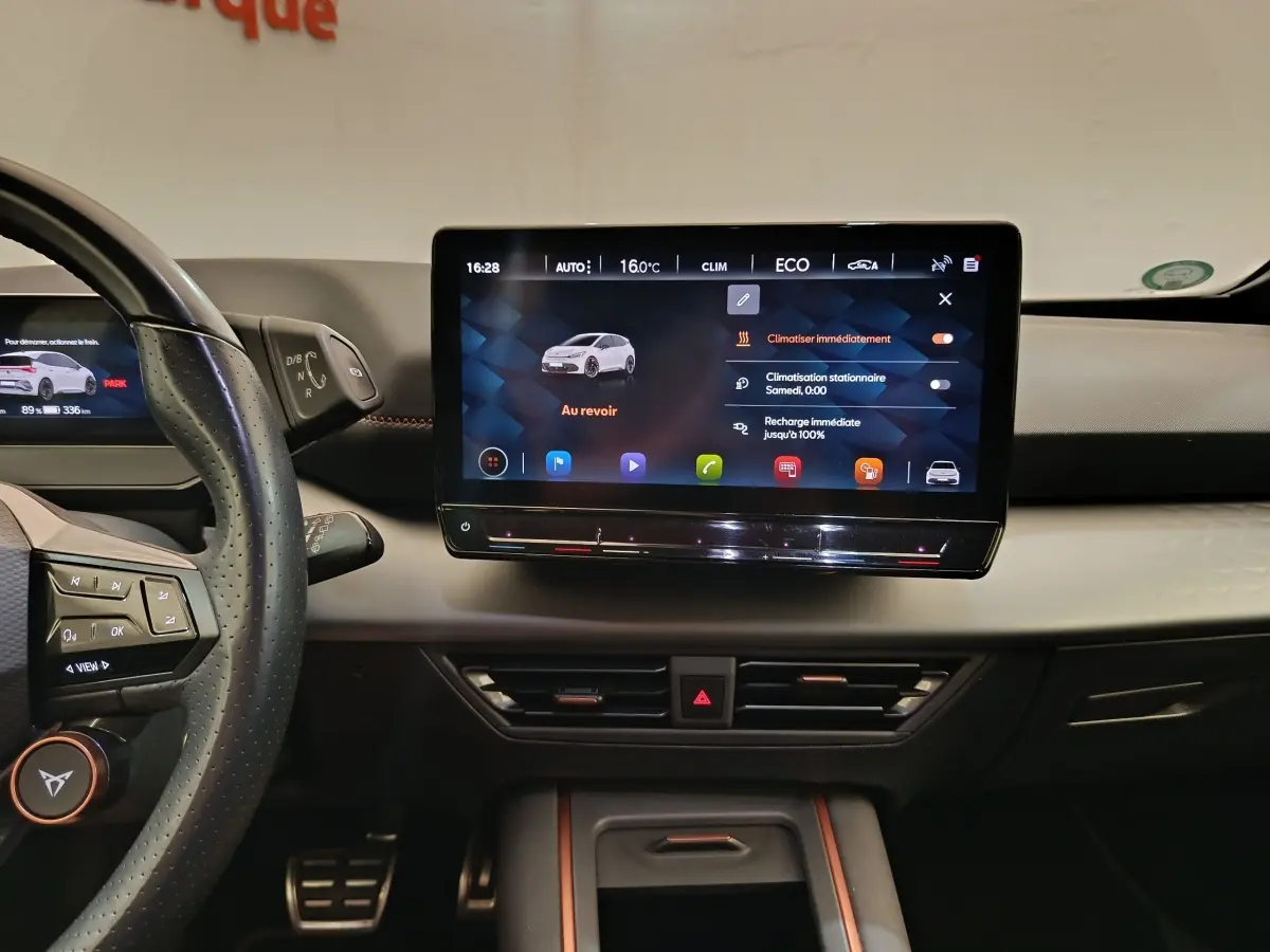 Vue intérieure du tableau de bord du CUPRA Born 230ch, écran tactile central 12 pouces avec interface climatisation et recharge.