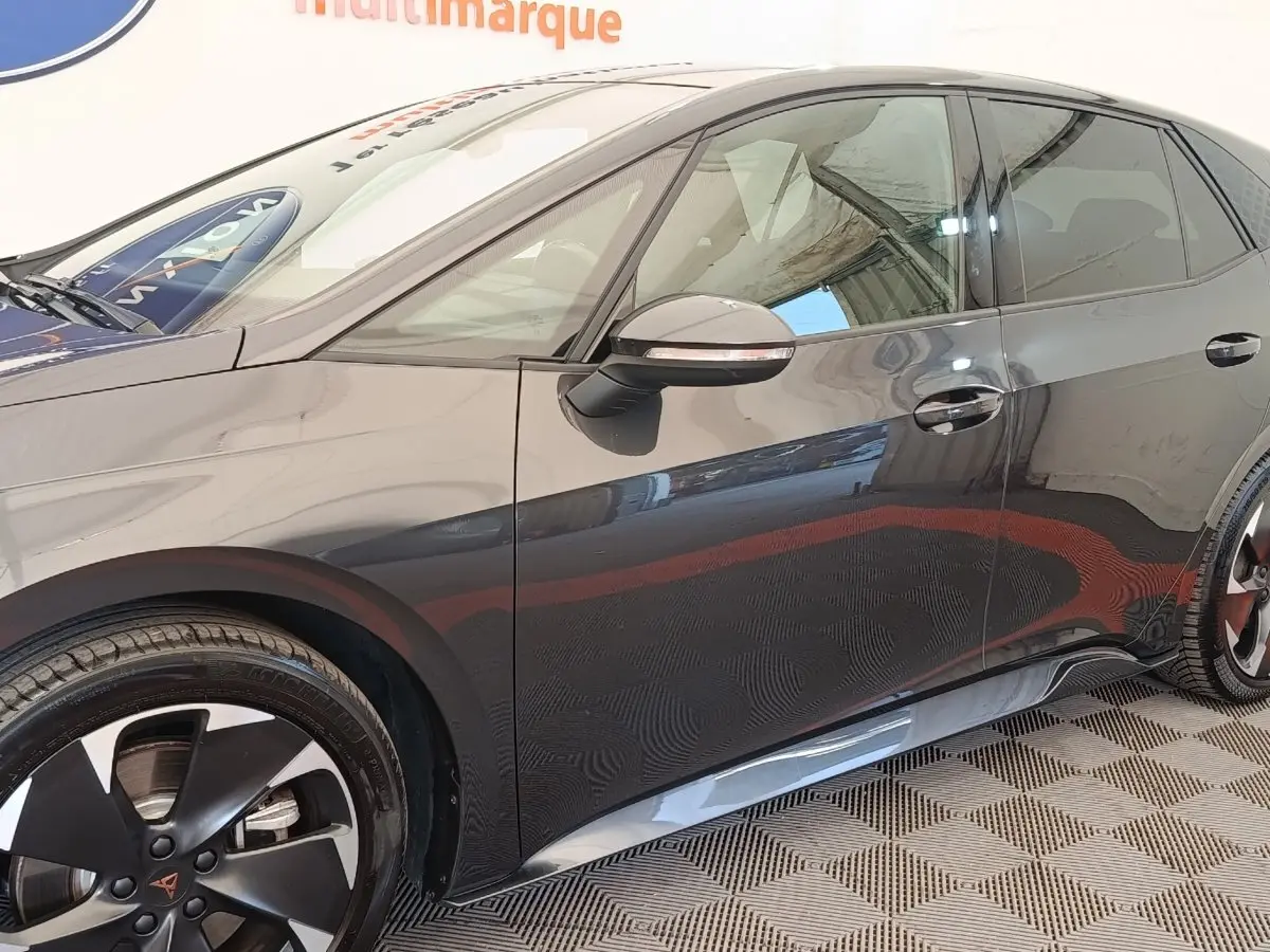 Profil côté gauche de la CUPRA BORN gris foncé 230ch, avec jantes noires et rétroviseurs rabattables électriquement.