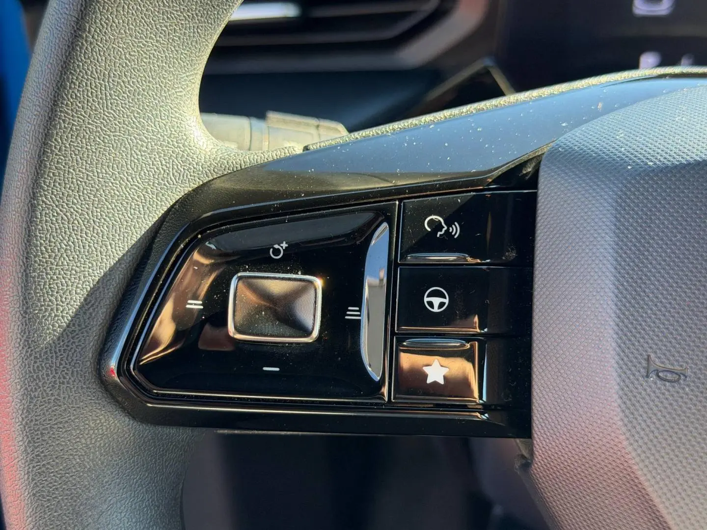 Gros plan sur les commandes multifonctions noires du volant côté gauche du MG3 Como Blue 2025.