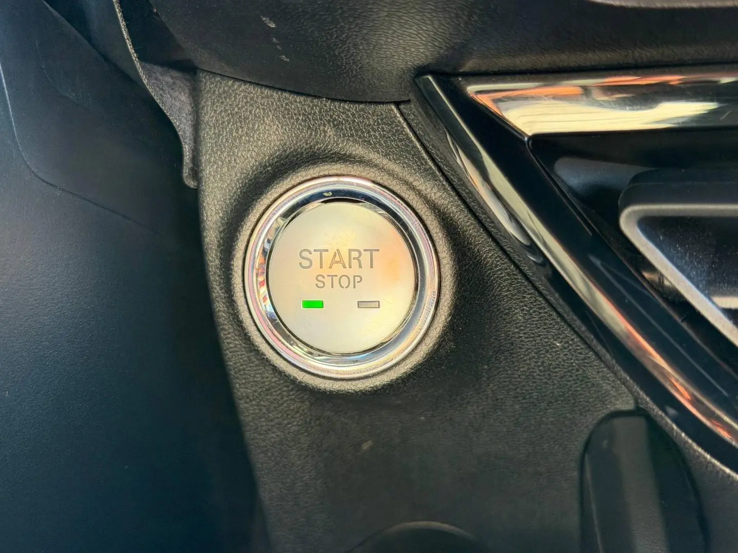 Détail du bouton Start/Stop entouré de chrome dans l'habitacle noir du MG3 1.5 Hybrid+ 2025.
