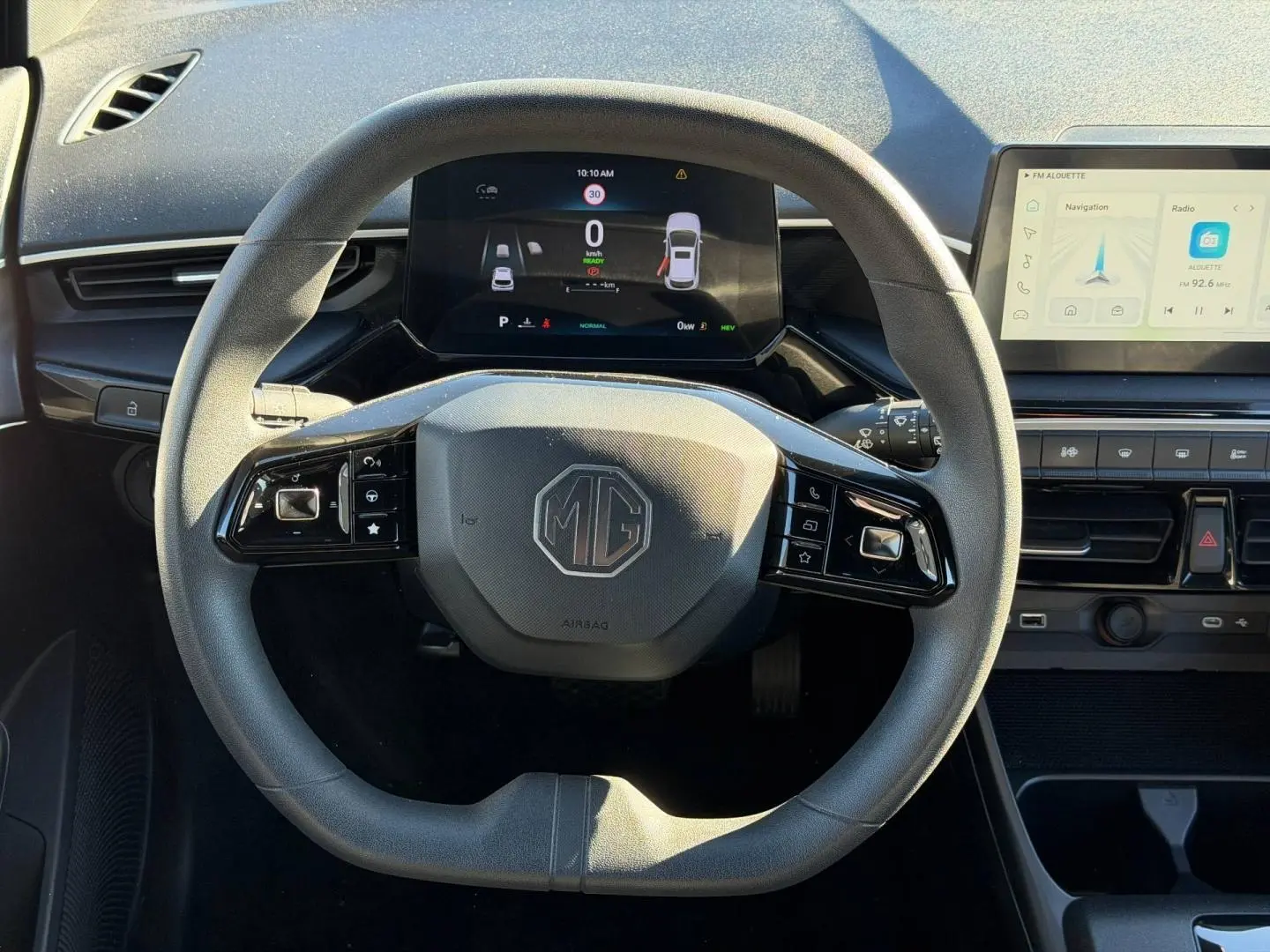 Vue frontale du volant noir multifonction MG3 1.5 Hybrid+ avec tableau de bord numérique et écran tactile latéral.
