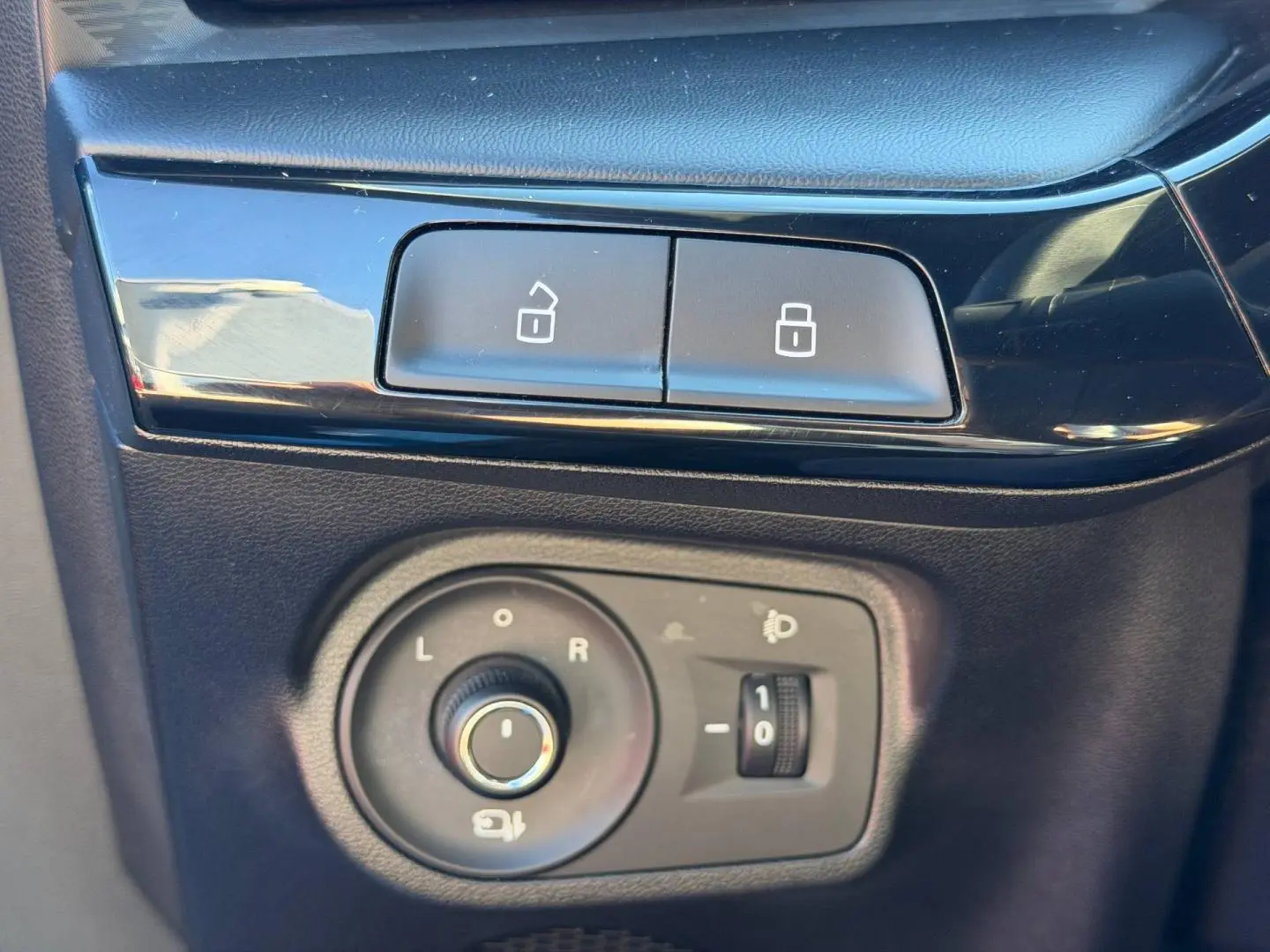 Gros plan sur les commandes de verrouillage et réglage des rétroviseurs noirs dans une MG3 Como Blue 2025.