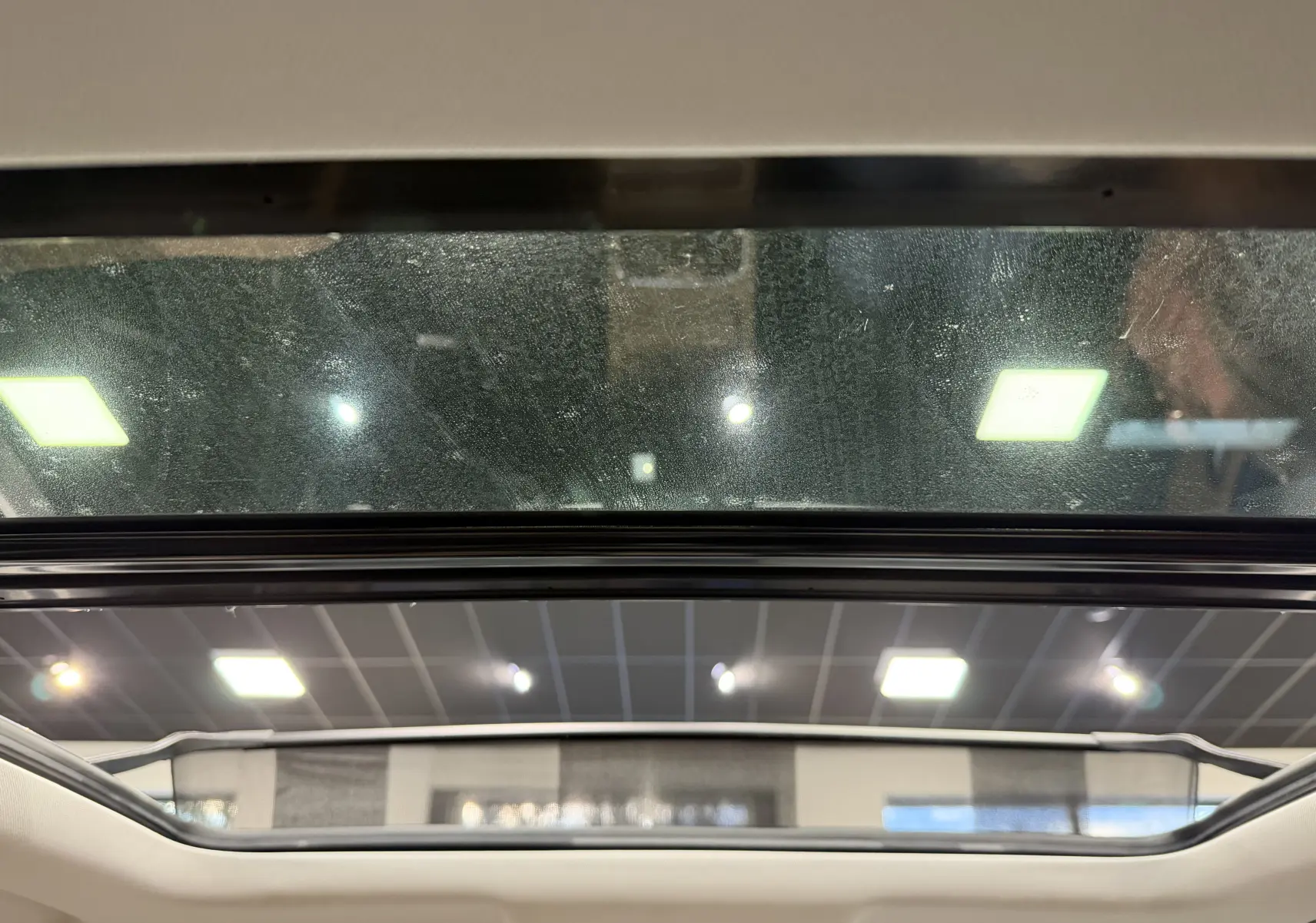 Toit panoramique ouvert vu de l'intérieur du Jaecoo J7 gris olive, mettant en valeur la luminosité naturelle.