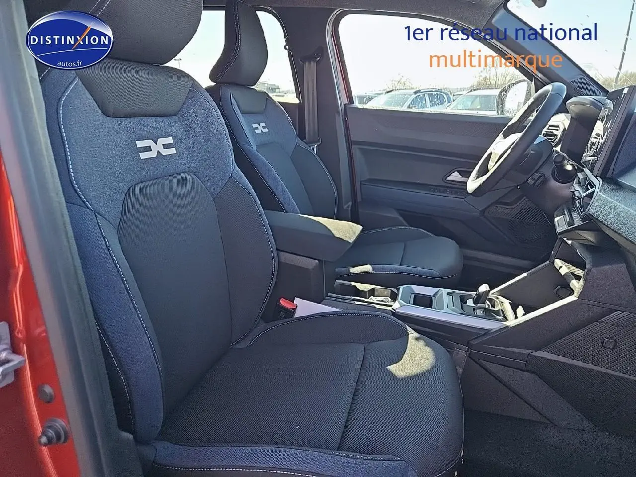 Vue intérieure côté gauche du Dacia Duster 2025 brun terracotta, mettant en valeur les sièges avant et le tableau de bord.