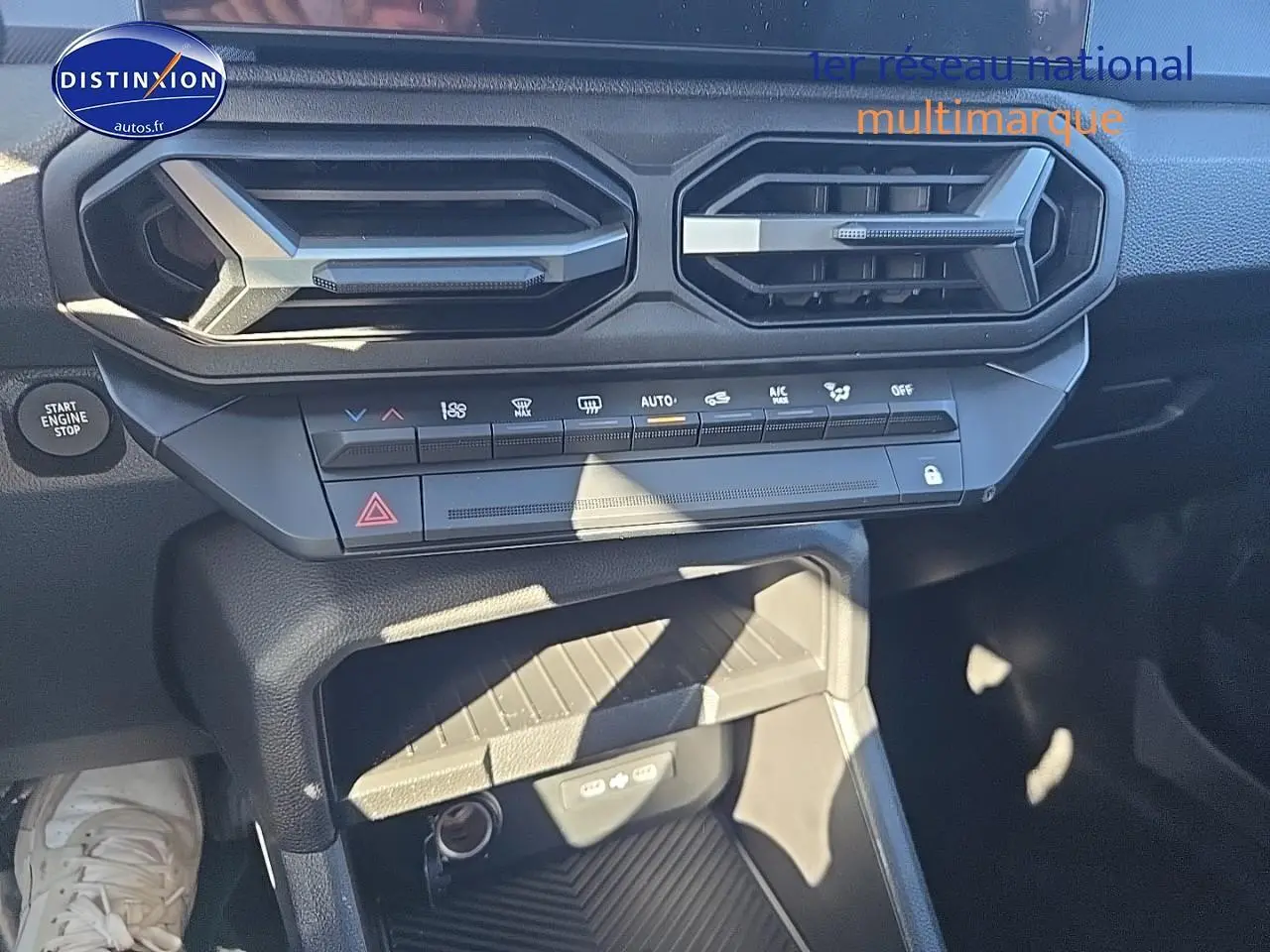 Détail intérieur du tableau de bord du Dacia Duster 2025 avec commandes climatisation et prise USB visibles
