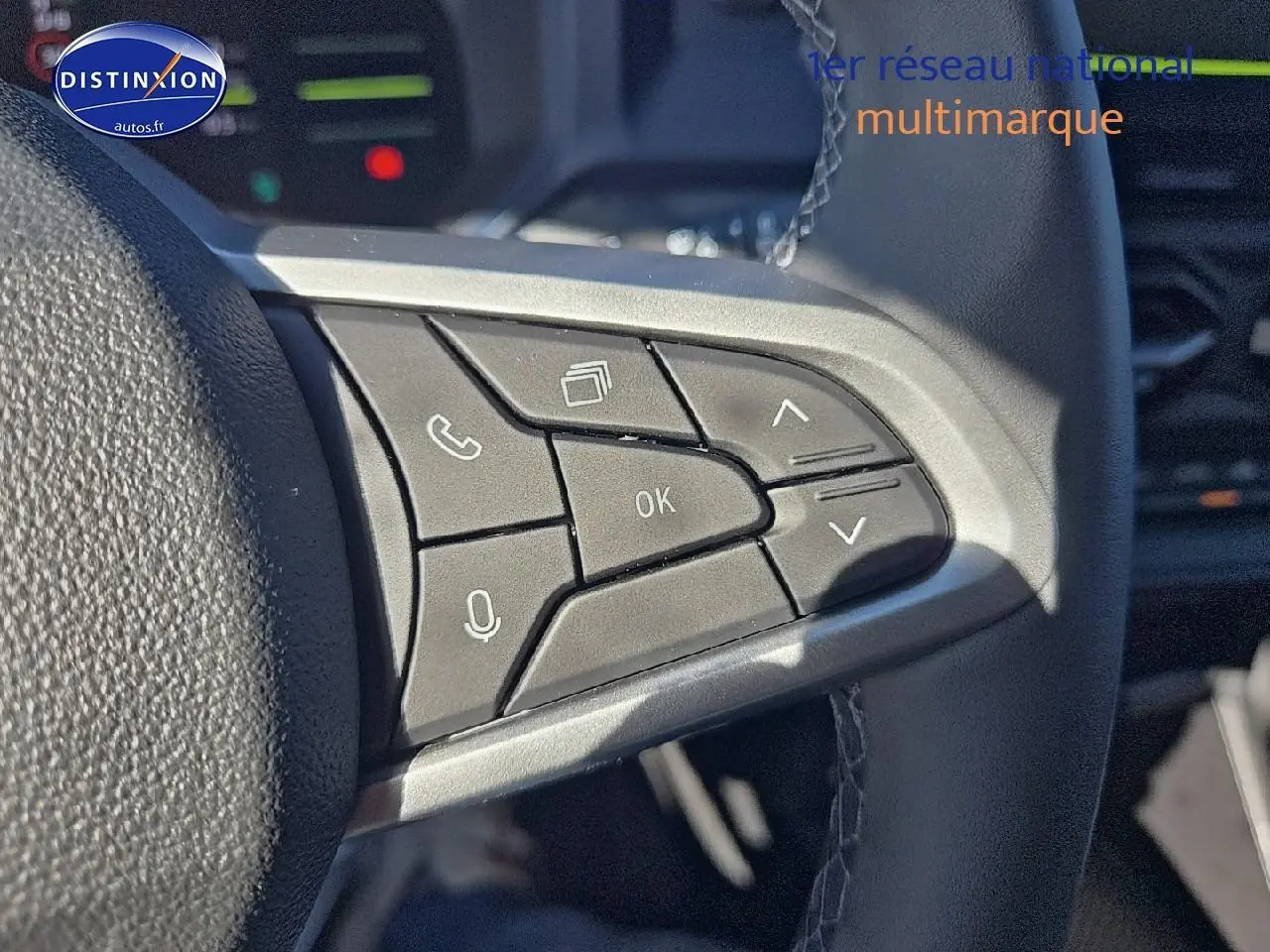 Gros plan sur les commandes multifonctions du volant du Dacia Duster brun terracotta 2025, côté gauche.