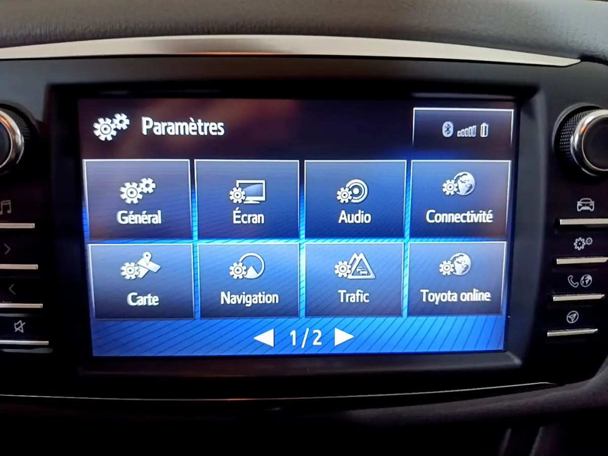 Écran tactile central de la Toyota Yaris 1.5 Hybride 2020 affichant le menu des paramètres en intérieur noir.