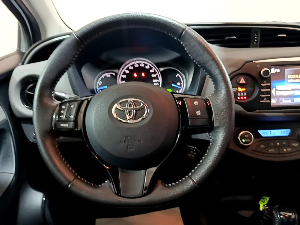 Vue centrée sur le volant cuir noir de la Toyota Yaris 1.5 Hybride 2020 avec tableau de bord et écran tactile visible.