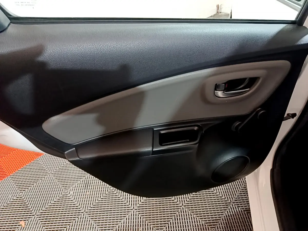 Vue intérieure côté droit de la porte arrière blanche de la Toyota Yaris 1.5 Hybride 2020 avec poignée et haut-parleur intégrés.