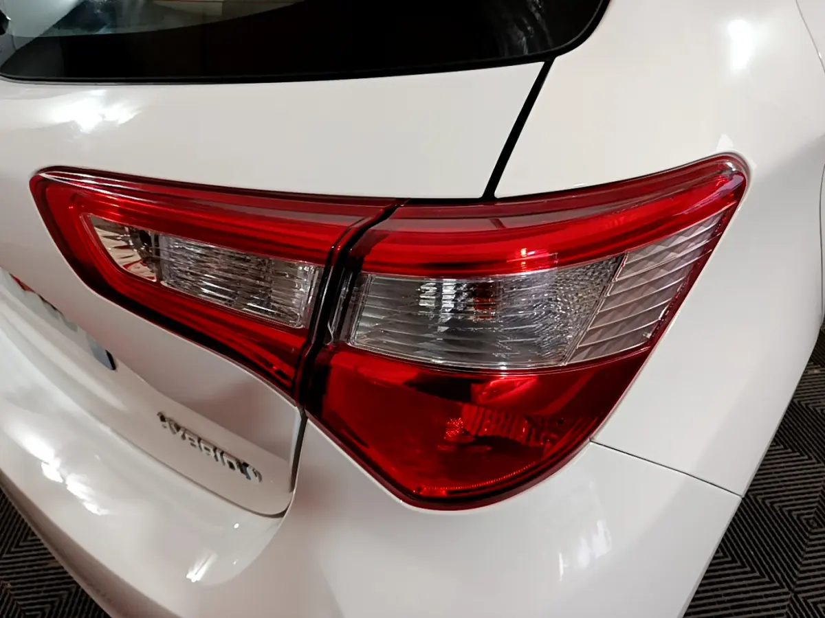 Gros plan sur le feu arrière droit rouge et blanc d'une Toyota Yaris blanche, version hybride 2020.