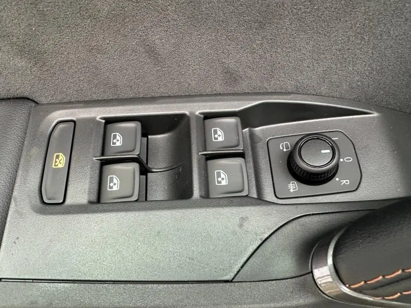 Vue rapprochée des commandes de lève-vitres et réglage des rétroviseurs côté conducteur du CUPRA Formentor gris Graphène.